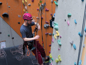 Man route setting on a rope